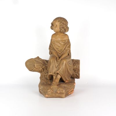 statue représentant un garçon assis sur une bûche avec un chien