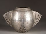 a silver vase that is sitting on a table