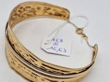a close up of a gold bracelet with a tag on it