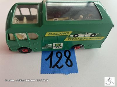 un petit bus vert orné d'un ruban bleu