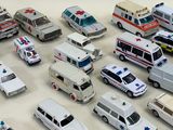 many different types of toy ambulances on a white surface