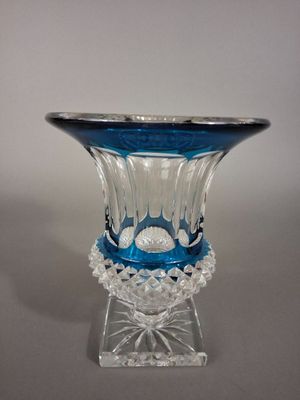 a blue glass vase with a clear base on a table