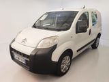 une petite camionnette blanche aux finitions noires garée dans une pièce blanche