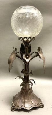 une lampe posée sur un pied et surmontée d'une boule en verre