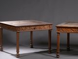 deux tables en bois dont le plateau est orné de sculptures, sur fond gris
