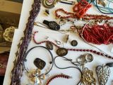 many different types of necklaces and bracelets laid out on a table