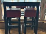 deux tabourets rouges posés près d'une table au milieu d'une pièce