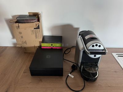 a coffee maker that is sitting on the floor next to a box