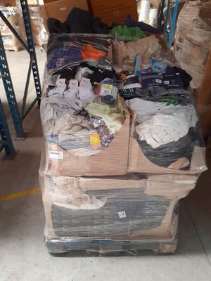 un gros tas de vêtements posé sur une palette dans un entrepôt
