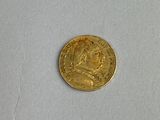 a close up of a gold coin on a white surface