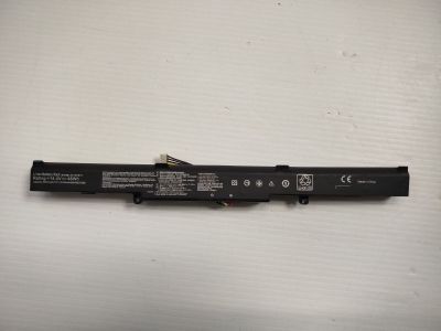 On voit une batterie d'ordinateur portable posée sur une surface blanche