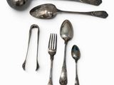 a spoon, fork, and spoon rest on a white surface