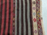 a close up of a striped rug on a white surface