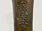 a bronze vase with a design on the outside of it