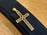 gold cross on a black tie on a wooden table
