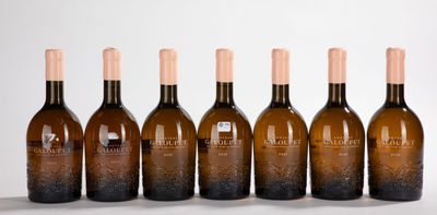 six bouteilles de vin sont alignées sur une table