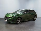 a green car is parked in a room with a white wall