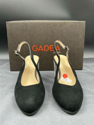 une paire de chaussures noires posée sur une boîte