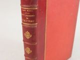 un vieux livre rouge posé sur une table blanche