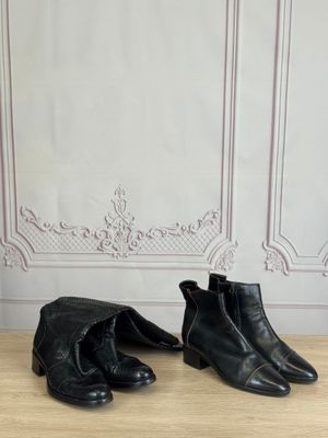 pair of black leather ankle boots on a wooden table