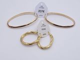 two pairs of gold hoop earrings and a pair of gold hoop earrings