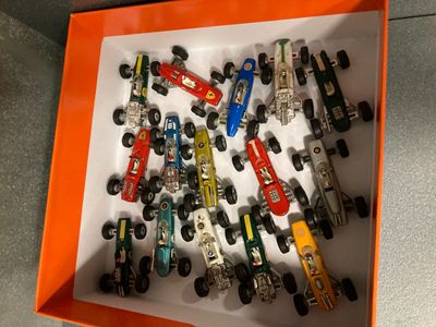 many toy cars in a box on the floor