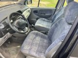 the interior of a small van with blue seats and a steering wheel