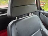 the interior of a car with black leather seats and red carpet