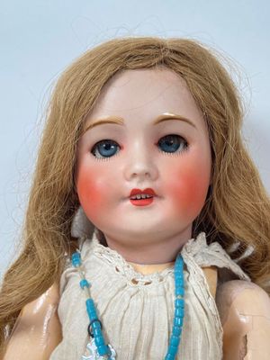 a close up of a doll with a necklace on it