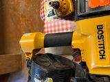 a yellow and black cordless nail gun on a wall