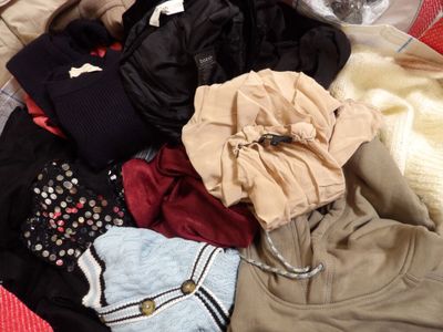 une pile de vêtements posée sur un lit