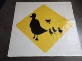 une affiche représentant un canard et ses canetons, posée sur une table