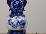 a blue and white vase sitting on top of a table