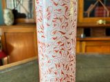 a red and white vase sitting on a table