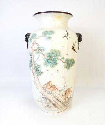 un vase blanc avec un tableau posé sur une table