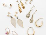 an assortment of earrings and rings on a white surface
