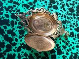 a silver locke with a picture on it on a green surface