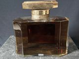 an image of a bottle of perfume sitting on top of a table