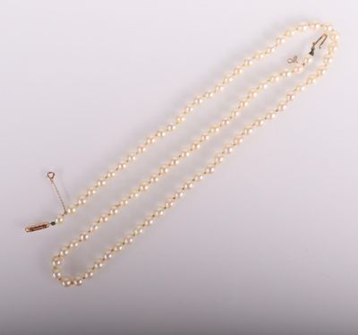 a close up of a necklace with pearls on a white background