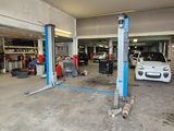 une voiture dans un garage où il y a beaucoup d'outils par terre