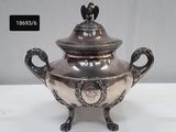 an image of a silver vase with a bird on top of it