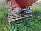 a red boat sitting on top of a wooden pallet