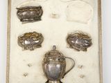 a box with silver objects in it on a white surface