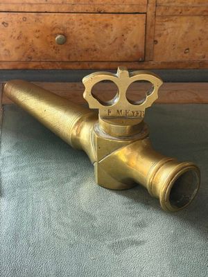a brass pipe that has a crown on top of it