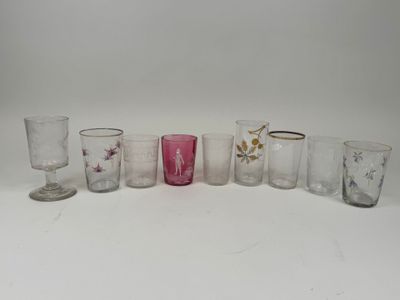 several different colored glasses are lined up on a white surface