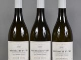 trois bouteilles de vin sont alignées sur une table