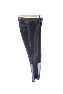 a black pants hanging on a clothes rack on a white wall