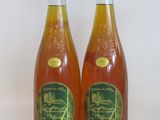 two bottles of wine sitting next to each other on a white surface
