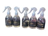 four bottles of cleaning products are lined up on a white surface