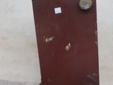a small red refrigerator sitting on a small wooden stand